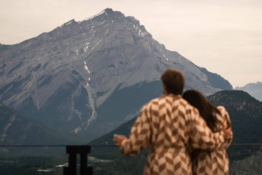 Guests on a terrace at Rimrock Banff looking across the Bow Valley