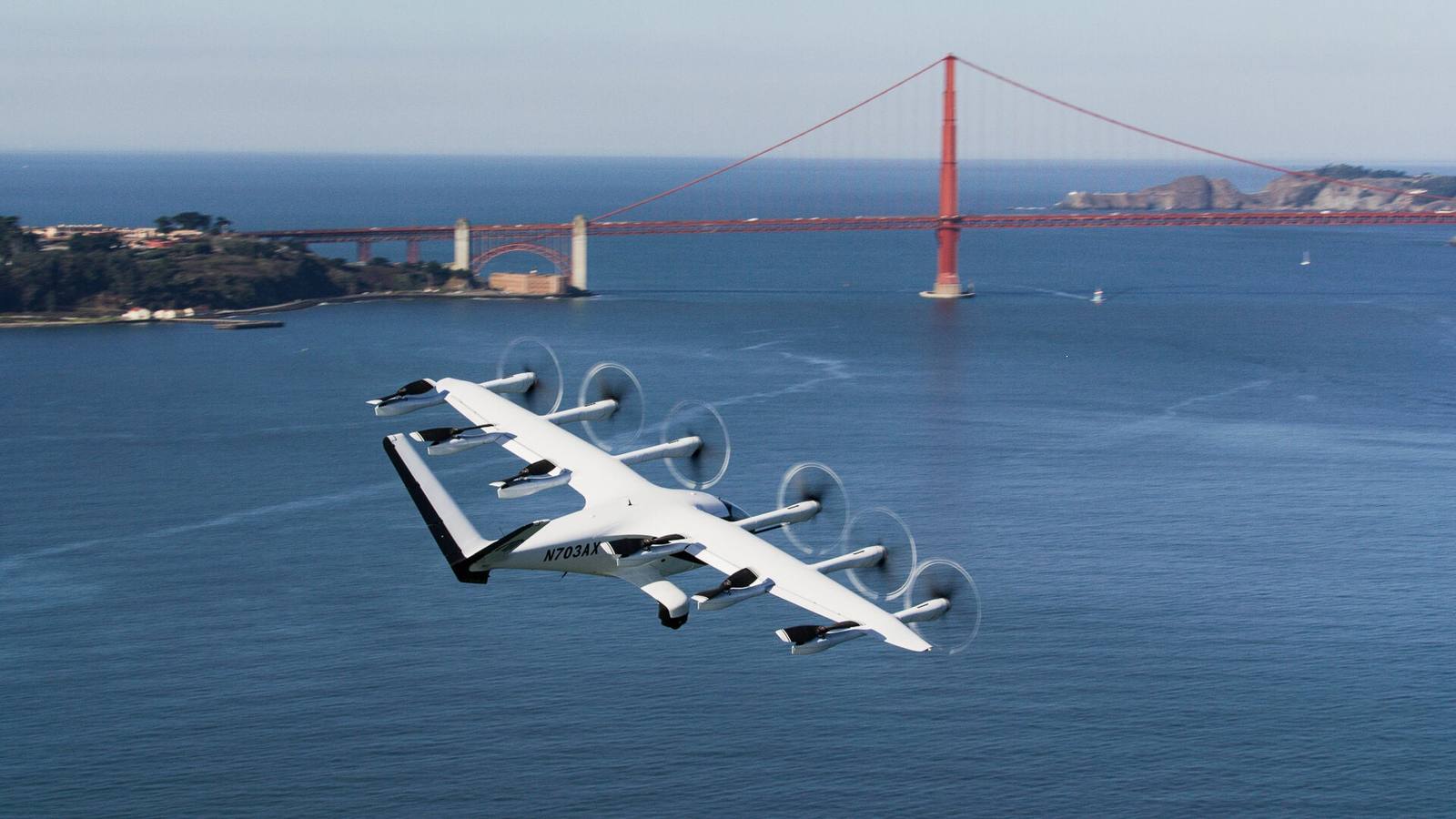Archer Aviation's Midnight air taxi, registration N703AX, in flight over San Francisco Bay with the Golden Gate Bridge behind it