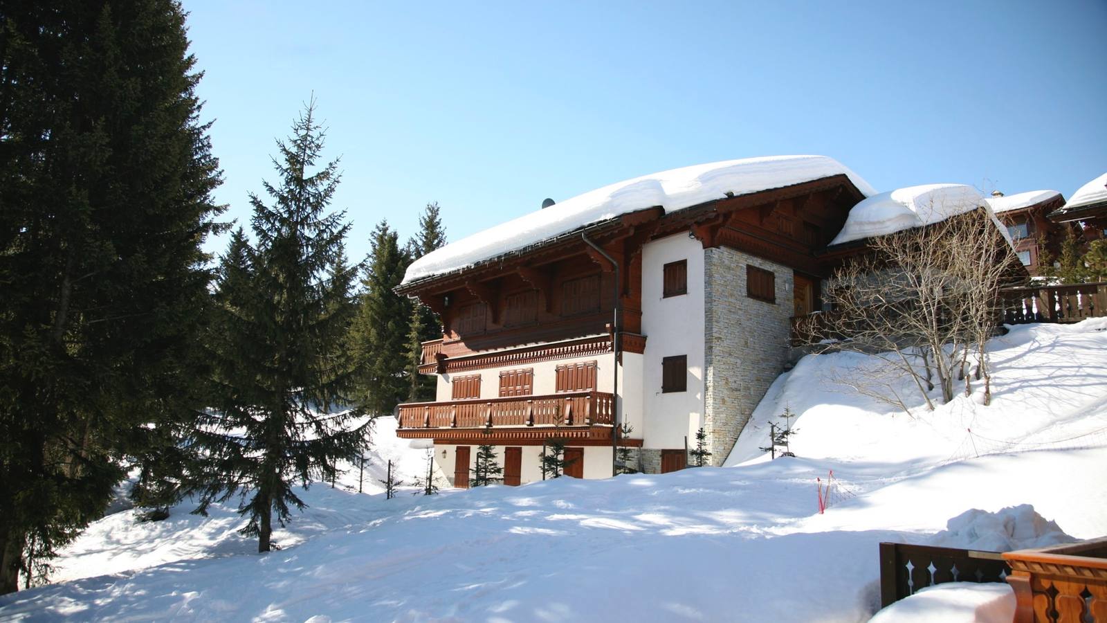 A snow-covered chalet in Courchevel 1850 under a clear blue sky
