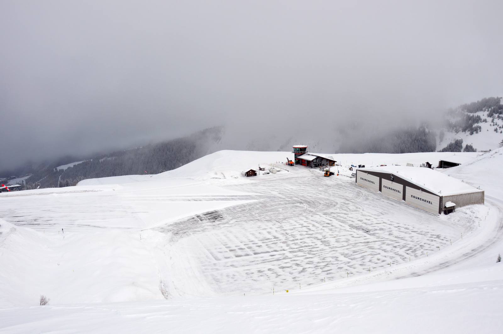 Courchevel altiport in winter with the snow-covered runway, control tower and hangar