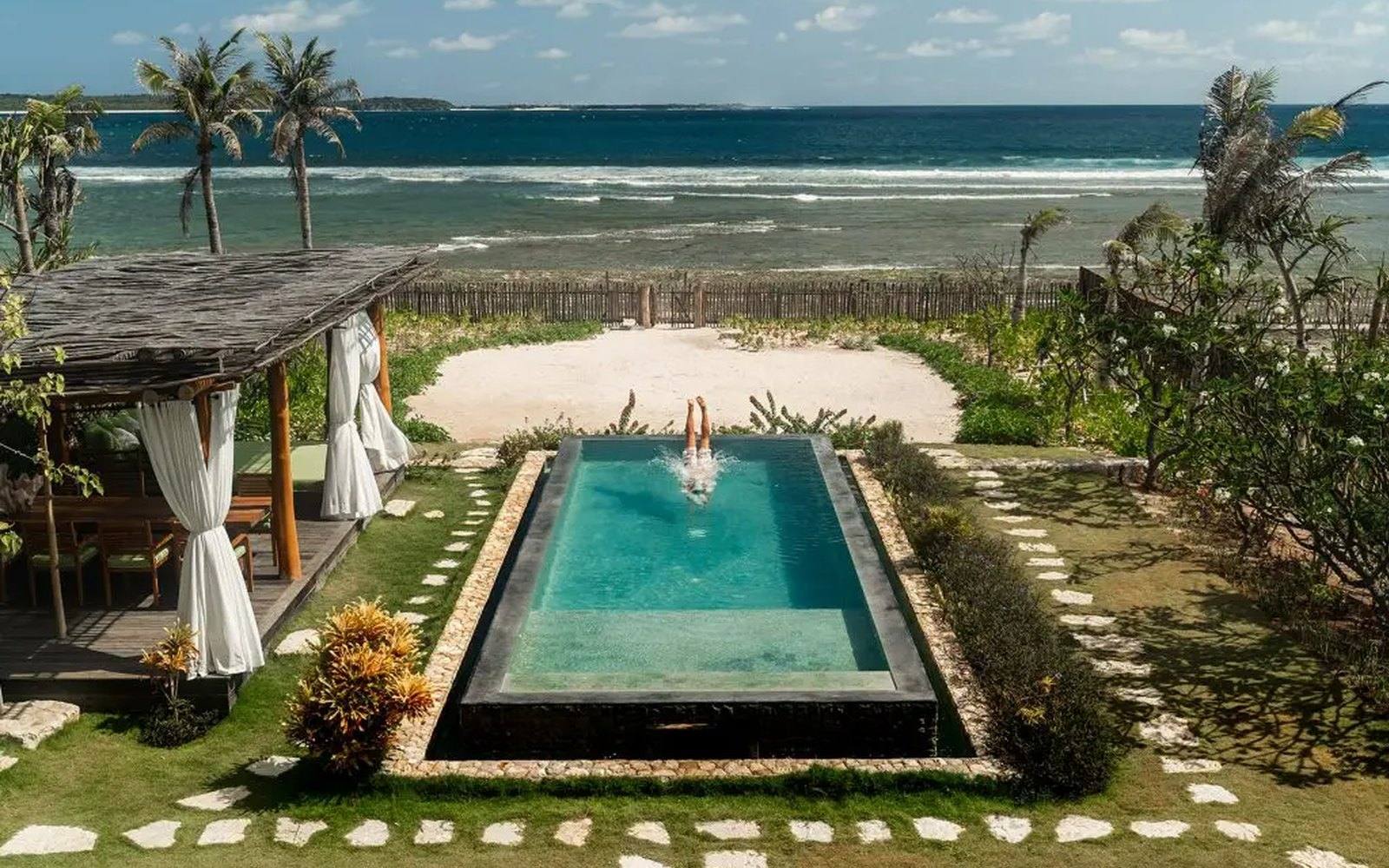 A guest in a private plunge pool at a NIHI Rote beachfront villa